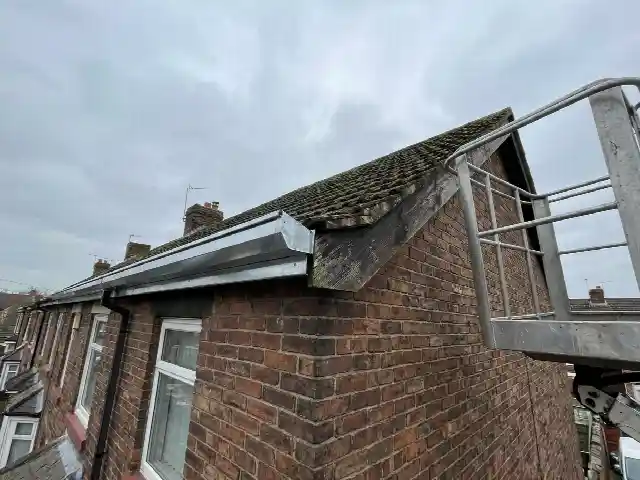 Nieuwe zinken bakgoot aan de dakrand van een rijwoning